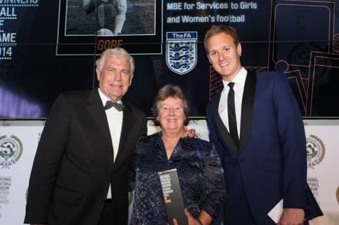Sylvia Gore receives her National Football Museum Hall Of Fame award from Sir Trevor Brooking and host Dan Walker.